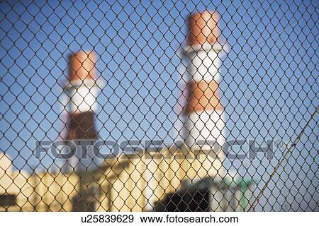 Stock Photo - USA, New York City, Industrial plant behind wire mesh fence. Fotosearch