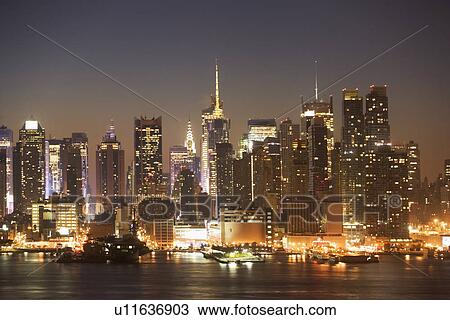 Stock Image - USA, New York City, Manhattan skyline at dusk. Fotosearch