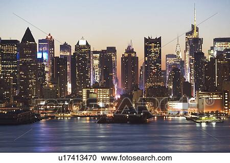 Stock Image - USA, New York City, Manhattan skyline at dusk. Fotosearch
