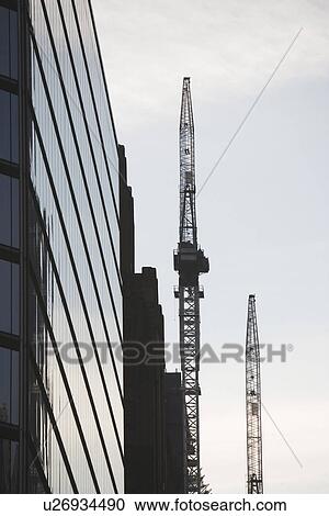 USA, New York City, Modern office building and cranes in background View Large Photo Image Stock Image - USA, New York City, Modern office building and cranes in background. Fotosearch