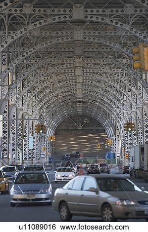 Stock Photograph - USA, New York City, Traffic passing under bridge. Fotosearch