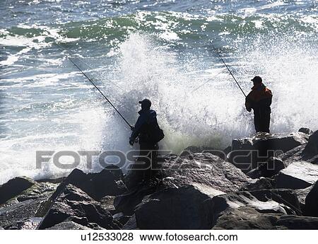 Stock Photo - USA, New York, Long Island, Montaurk, Men fishing in sea. Fotosearch