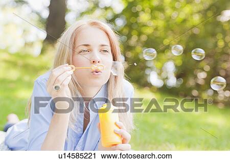USA, New York, New York City, Manhattan, Central Park, Woman blowing bubbles View Large Photo Image Stock Image - USA, New York, New York City, Manhattan, Central Park, Woman blowing bubbles. Fotosearch