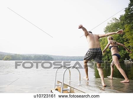 USA, New York, Putnam Valley, Roaring Brook Lake, Couple about to jump from pier to lake View Large Photo Image Stock Image - USA, New York, Putnam Valley, Roaring Brook Lake, Couple about to jump from pier to lake. Fotosearch