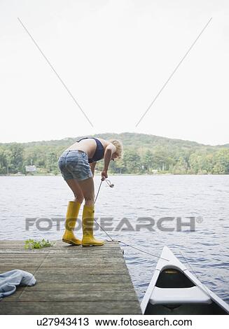 Stock Image - USA, New York, Putnam Valley, Roaring Brook Lake, Rear view of woman mooring boat. Fotosearch