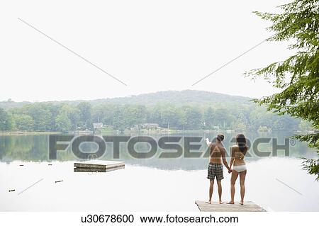 USA, New York, Putnam Valley, Roaring Brook Lake, Couple standing on pier by lake View Large Photo Image Stock Image - USA, New York, Putnam Valley, Roaring Brook Lake, Couple standing on pier by lake. Fotosearch