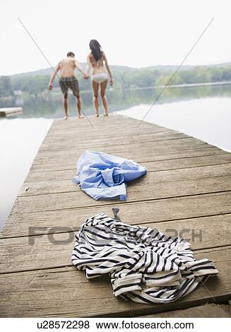 Stock Photo - USA, New York, Putnam Valley, Roaring Brook Lake, Couple standing on pier by lake. Fotosearch