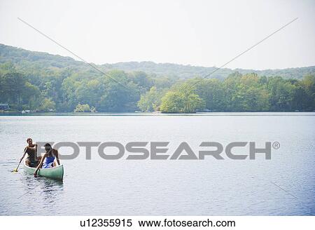 Stock Photography - USA, New York, Putnam Valley, Roaring Brook Lake, Couple in boat on lake. Fotosearch