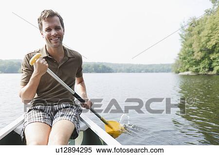 Stock Photography - USA, New York, Putnam Valley, Roaring Brook Lake, Man rowing boat. Fotosearch