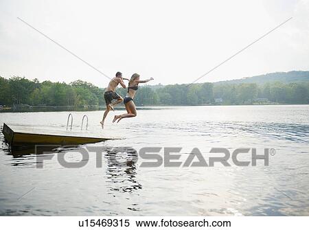 USA, New York, Putnam Valley, Roaring Brook Lake, Couple jumping from pier to lake View Large Photo Image Stock Photography - USA, New York, Putnam Valley, Roaring Brook Lake, Couple jumping from pier to lake. Fotosearch