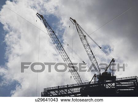 USA, New York State, New York City, Cranes on cloudy sky View Large Photo Image Stock Image - USA, New York State, New York City, Cranes on cloudy sky. Fotosearch
