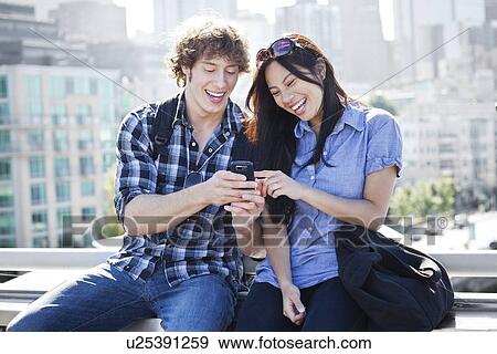 USA, Washington, Seattle, Couple looking at mobile phone View Large Photo Image Stock Photo - USA, Washington, Seattle, Couple looking at mobile phone. Fotosearch