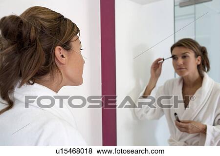 Woman applying make-up in bathroom View Large Photo Image Stock Photo - Woman applying make-up in bathroom. Fotosearch