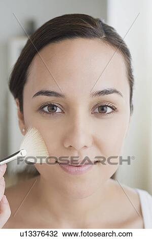 Stock Image - Woman applying make-up. Fotosearch