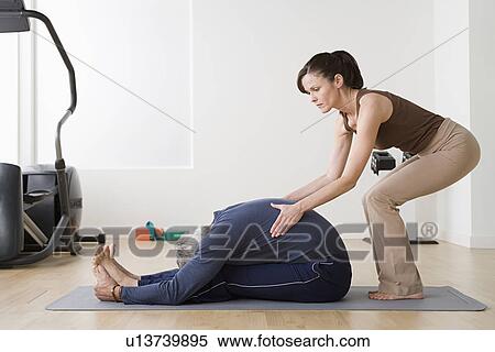 Woman assisting man in exercise in gym View Large Photo Image Stock Photography - Woman assisting man in exercise in gym. Fotosearch