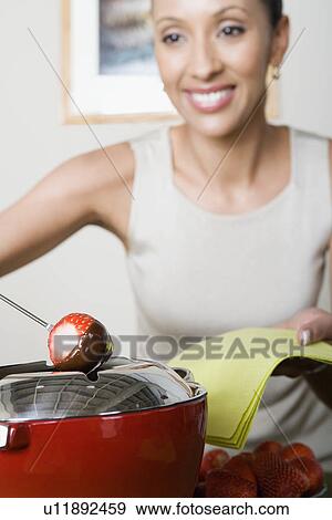 Woman dipping strawberries in chocolate mousse View Large Photo Image Stock Photo - Woman dipping strawberries in chocolate mousse. Fotosearch