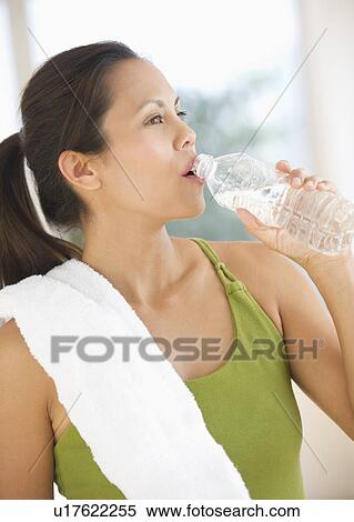 Stock Photography - Woman drinking water after training. Fotosearch