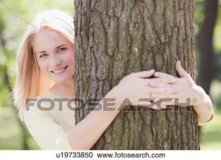 Stock Image - Woman embracing tree. Fotosearch