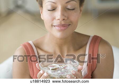 Stock Image - Woman enjoying aromatherapy. Fotosearch