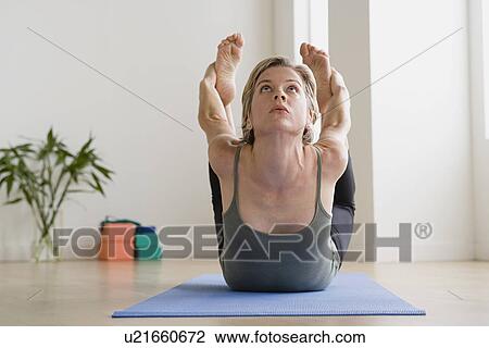 Stock Image - Woman exercising on mat. Fotosearch