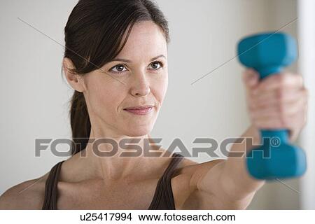 Woman exercising with dumbbell View Large Photo Image Picture - Woman exercising with dumbbell. Fotosearch