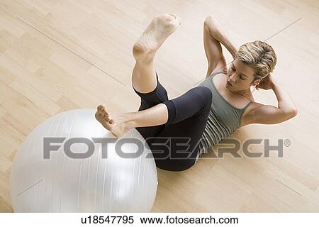 Woman exercising with fitness ball View Large Photo Image Stock Photography - Woman exercising with fitness ball. Fotosearch