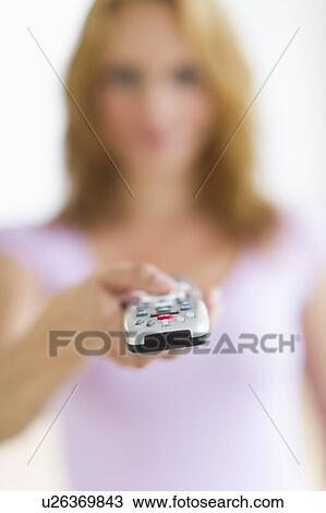 Woman holding remote control, focus on foreground, studio shot View Large Photo Image Stock Image - Woman holding remote control, focus on foreground, studio shot. Fotosearch