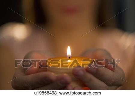 Stock Photo - Woman holding tealight. Fotosearch