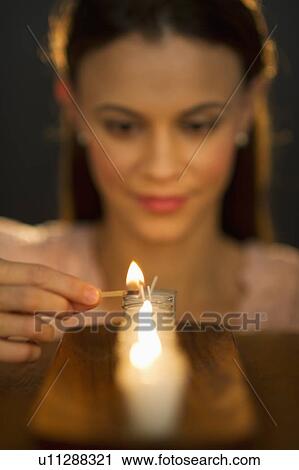 Woman igniting candle View Large Photo Image Stock Image - Woman igniting candle. Fotosearch