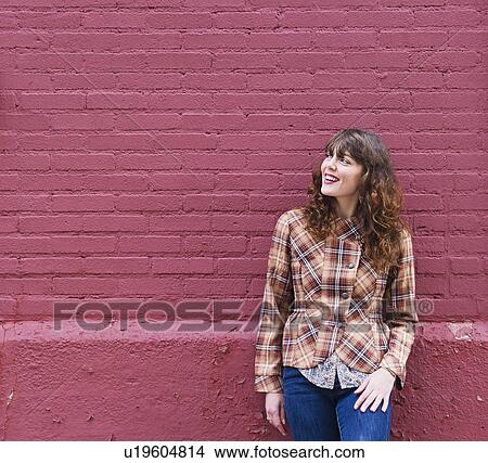 Woman leaning against purple brick wall View Large Photo Image Picture - Woman leaning against purple brick wall. Fotosearch