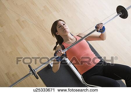 Stock Image - Woman lifting barbell. Fotosearch