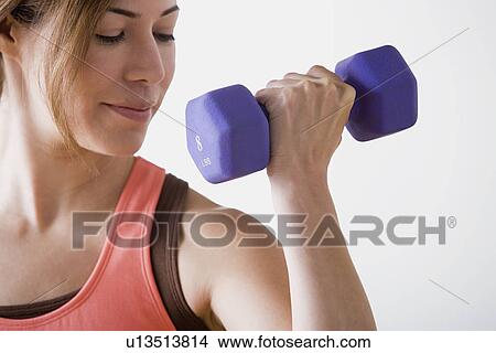 Woman lifting dumbbell View Large Photo Image Picture - Woman lifting dumbbell. Fotosearch