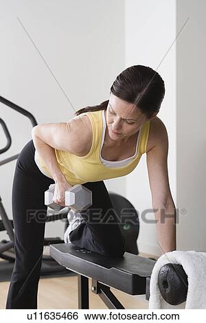Woman lifting weights in gym View Large Photo Image Stock Photograph - Woman lifting weights in gym. Fotosearch