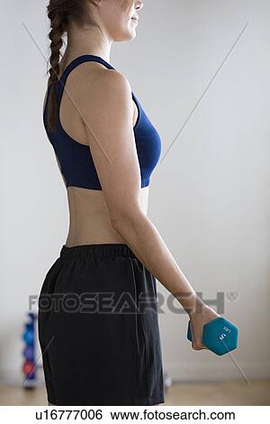 Woman lifting weights in gym View Large Photo Image Stock Photograph - Woman lifting weights in gym. Fotosearch
