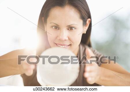 Stock Image - Woman looking into crystal ball. Fotosearch