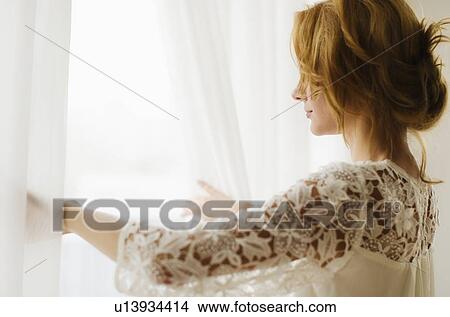 Picture - Woman looking out window. Fotosearch