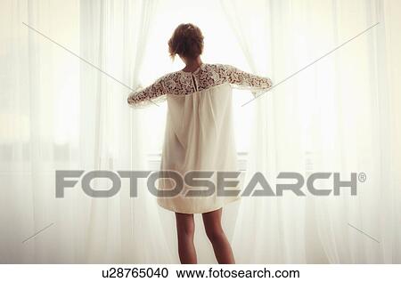 Stock Image - Woman looking out window. Fotosearch