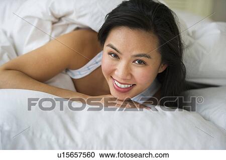 Stock Image - Woman lying in bed. Fotosearch
