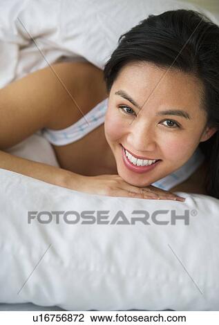 Stock Image - Woman lying in bed. Fotosearch