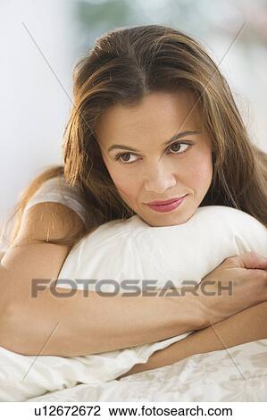 Stock Image - Woman lying on bed. Fotosearch