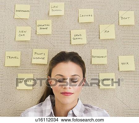 Picture - Woman lying on carpet with adhesive notes around head. Fotosearch