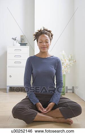 Woman meditating at home View Large Photo Image Stock Photograph - Woman meditating at home. Fotosearch