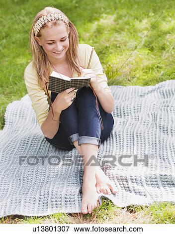 Woman reading book in park View Large Photo Image Stock Photo - Woman reading book in park. Fotosearch