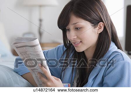 Woman reading newspaper at home View Large Photo Image Picture - Woman reading newspaper at home. Fotosearch