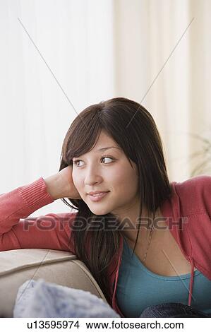 Picture - Woman relaxing on sofa. Fotosearch