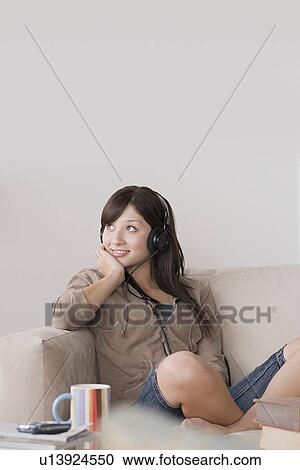 Stock Image - Woman relaxing on sofa. Fotosearch