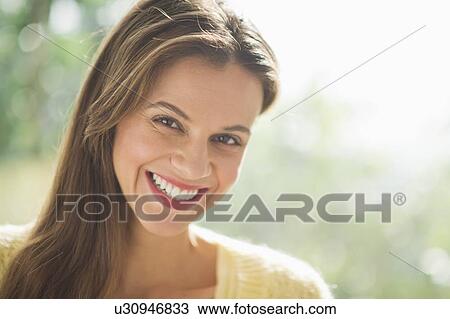 Stock Image - Woman smiling outdoors. Fotosearch