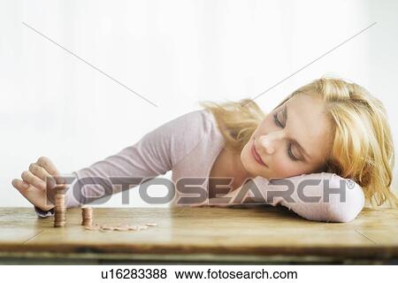Stock Photo - Woman stacking coins, studio shot. Fotosearch