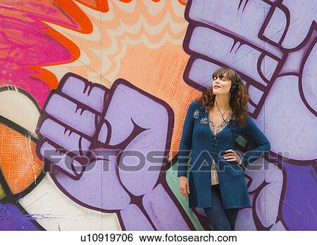 Woman standing against wall with graffiti View Large Photo Image Stock Photograph - Woman standing against wall with graffiti. Fotosearch