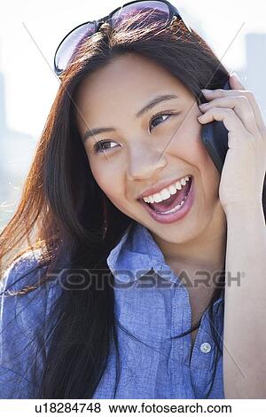 Woman talking on mobile phone outdoors View Large Photo Image Stock Photo - Woman talking on mobile phone outdoors. Fotosearch